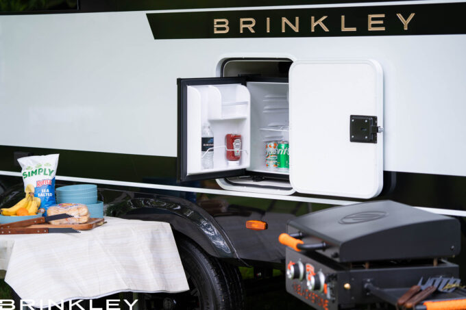 Luxury Travel Trailer's camp site with a camp-side 12-volt refrigerator and grill ready for outdoor cooking and entertaining.