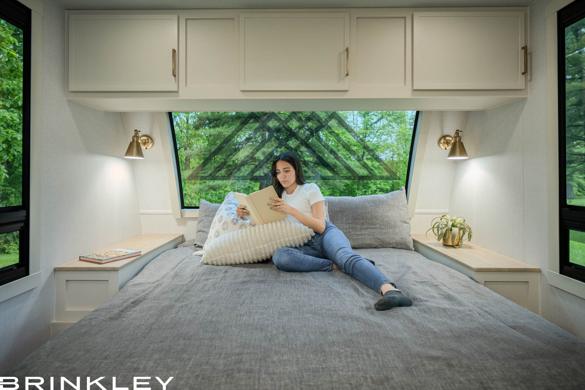 nterior view of the Brinkley RV Model I 294 master suite featuring the automotive-grade Picture Perfect front window and residential king mattress. Known for building the highest quality travel trailers, Brinkley engineers this bedroom with panoramic views and integrated bedside storage to solve common space and lighting issues found in traditional coaches.