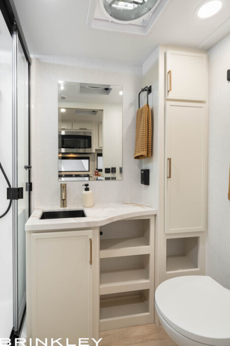 Luxury bathroom interior with a porcelain toilet and stainless steel sink in a Brinkley RV Model Ix 20x short small compact travel trailer