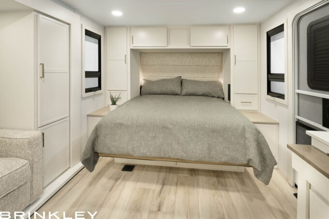 Small compact travel trailer interior featuring the Brinkley RV Model Ix 20x Feather-Lift Hidden Bed system lowered for sleep