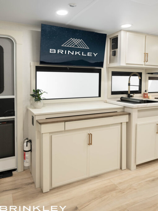 Living room entertainment hutch with a 40 inch Smart TV on an articulating mount in a Brinkley RV Model Ix 20x short small compact travel trailer