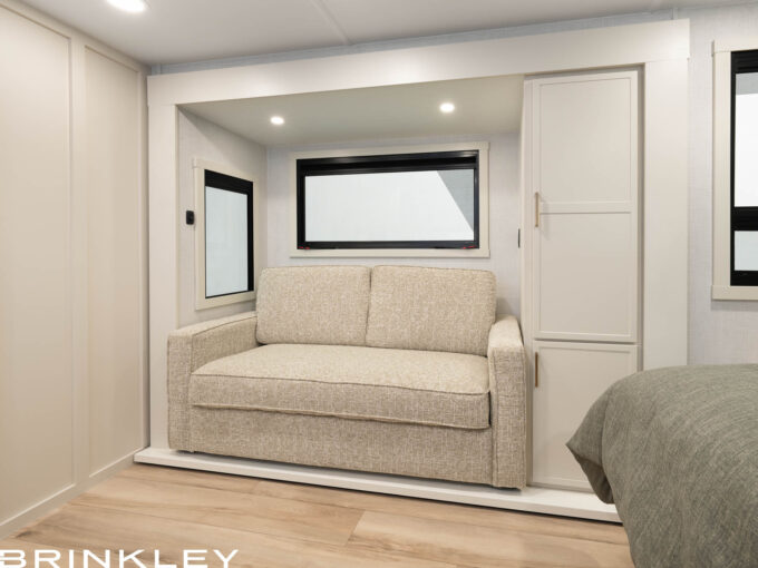 Living area of a short small compact travel trailer featuring a luxury Tri-Fold sleeper sofa by Brinkley RV