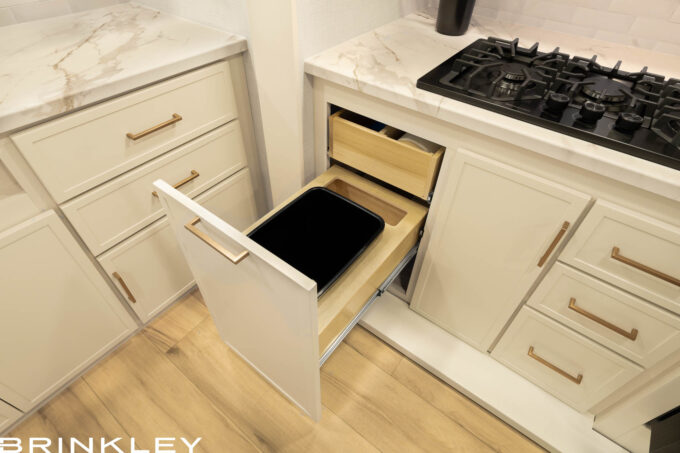 Integrated waste management solution in the Brinkley Model Ix 23x luxury travel trailer kitchen showing backup bag storage