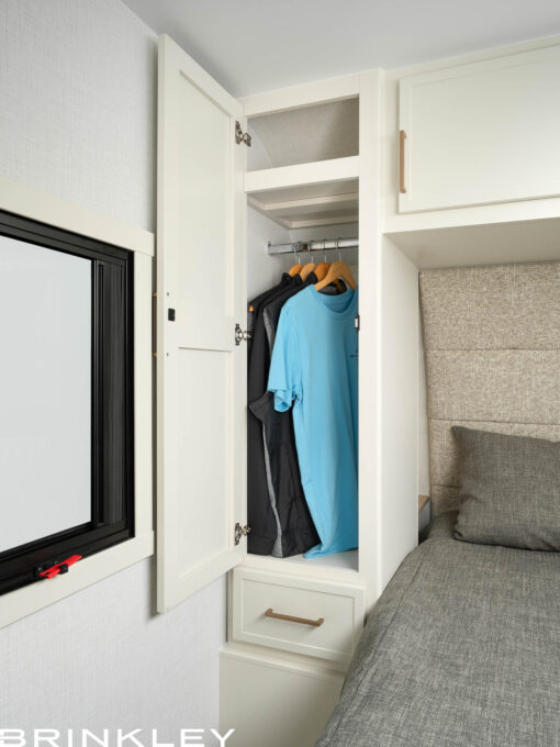 Dual residential-style wardrobes in a Brinkley Model Ix 24x travel trailer bedroom providing hanging and drawer storage